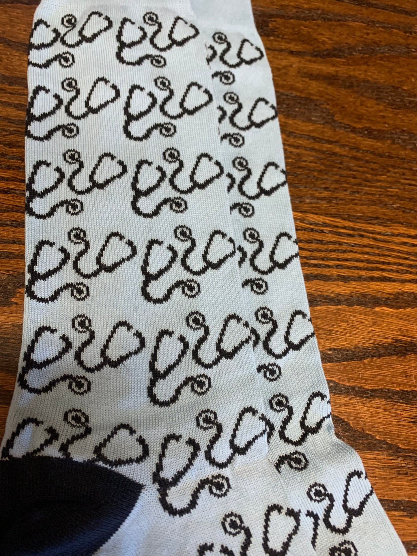 White sock with repeating black stethoscope pattern on wooden surface