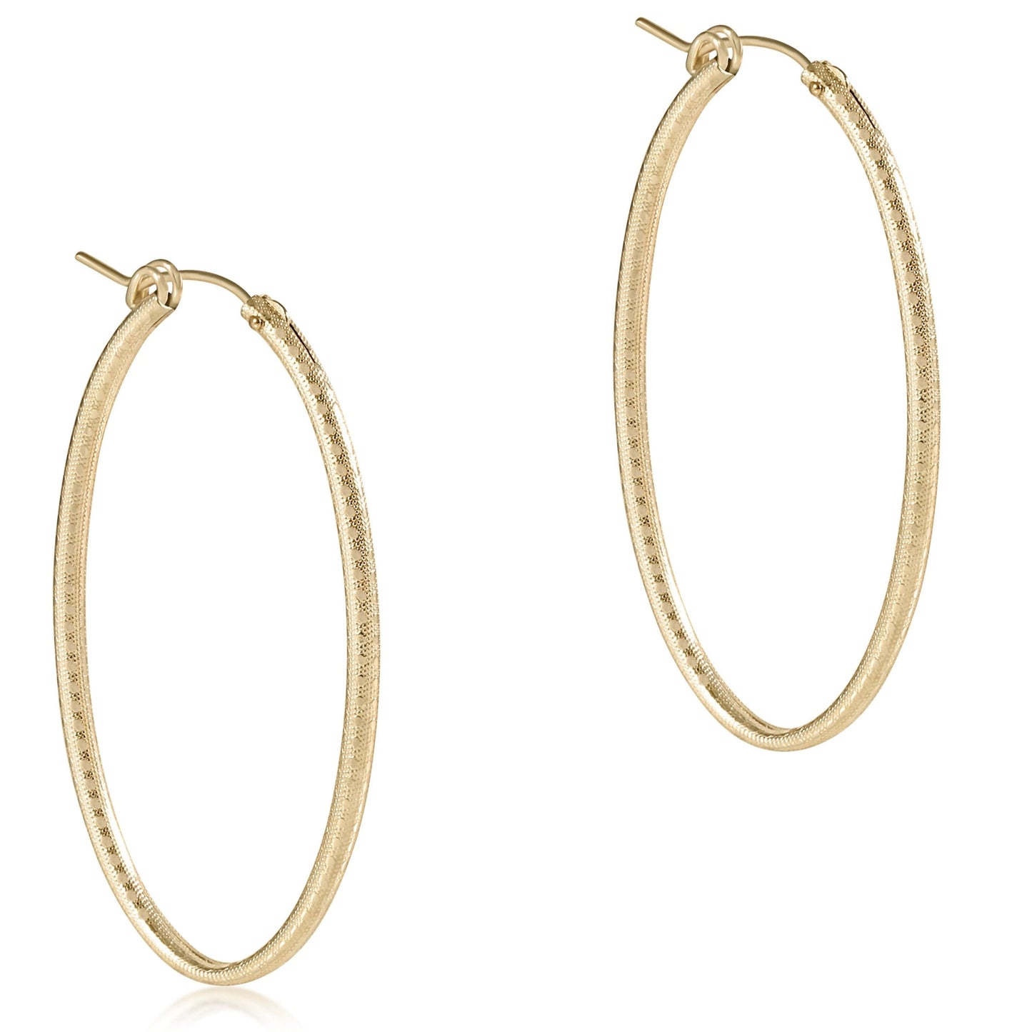 Pair of oval gold 2-inch textured hoop earrings with post closure on white background