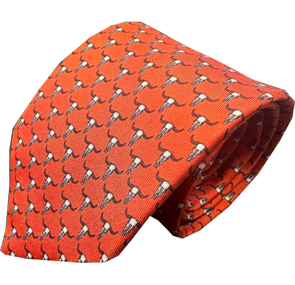 Orange silk tie with small white and black bull head pattern arranged in diagonal rows