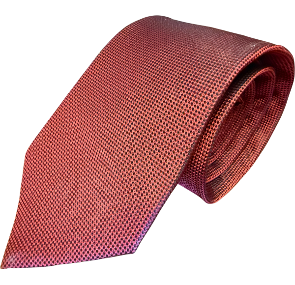 Red textured necktie with fine geometric pattern rolled against black background