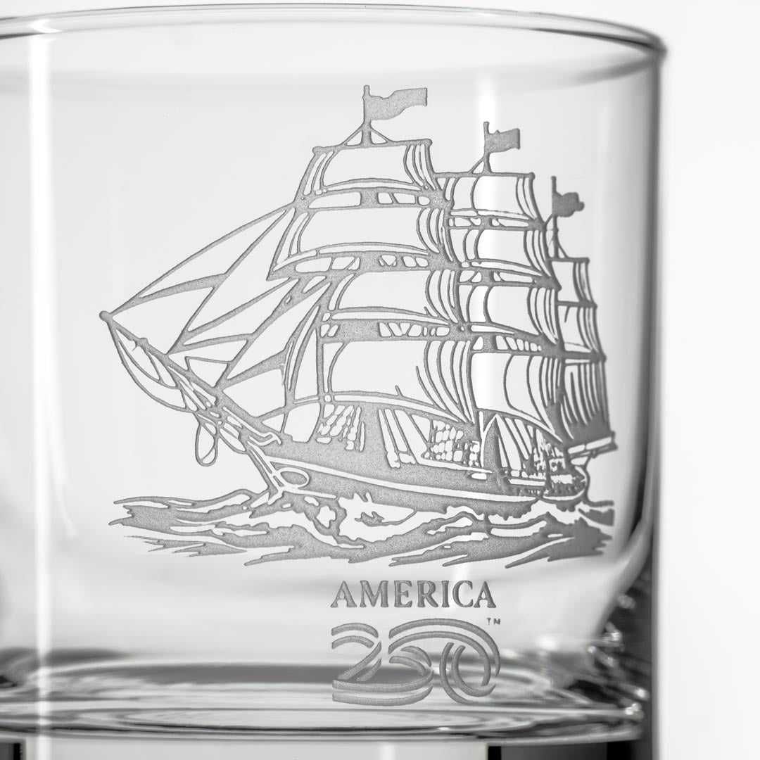 Clear whiskey glass with etched tall ship design and America250 logo