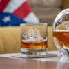 America250 engraved whiskey glass with tall ship design next to matching decanter