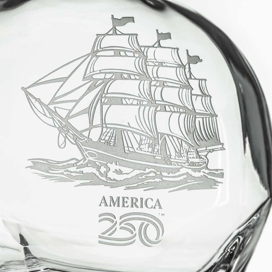 Close-up detail of etched tall ship design on clear glass whiskey decanter