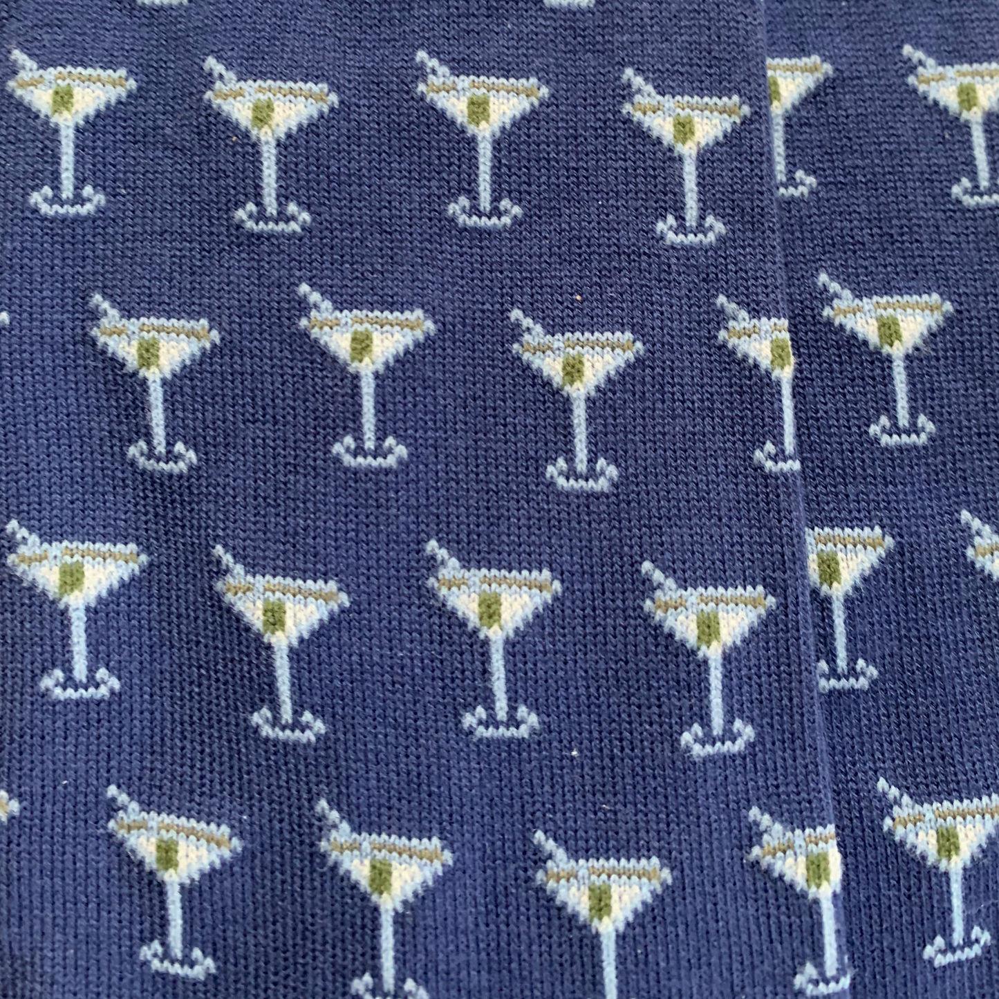 Navy blue knitted socks with repeating martini glass pattern in white, yellow and green