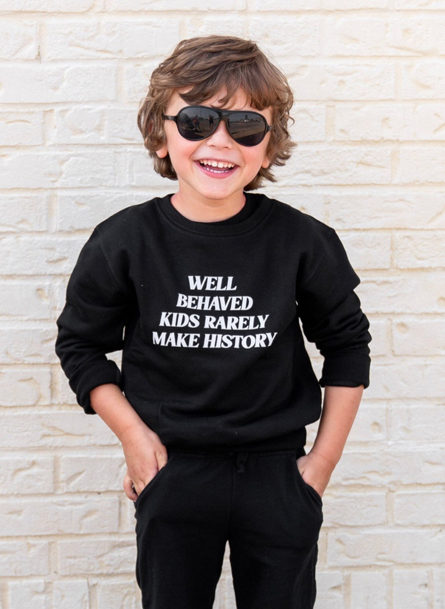 Love Bubby Well Behaved Kids Rarely Make History, Kids Black Sweatshirt available at The Good Life Boutique