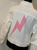 Moving Forward Designs Moving Forward Pink Bolt and Stud White Denim Jacket available at The Good Life Boutique